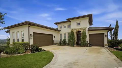 La Cantera - dusk exterior of a tan stucco home with a three-car garage