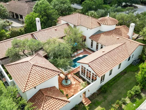 Shavano Park - aerial view of a red tile-roof estate home with a courtyard fountain and pool