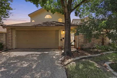 Hill Country Village - stone and stucco home with a two-car garage